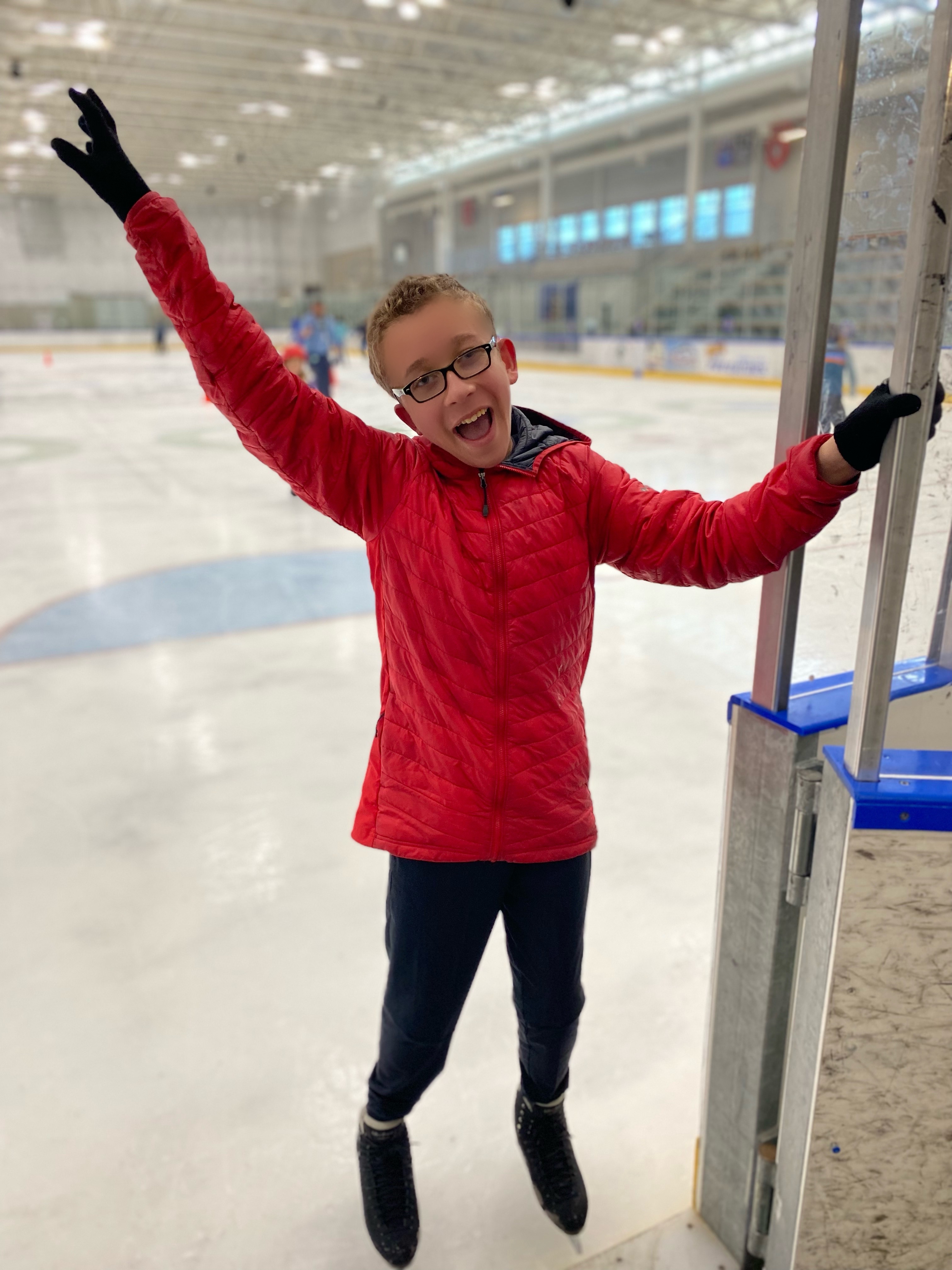 Cole Rohner stands at the entrance to the ice with a big smile on his face.