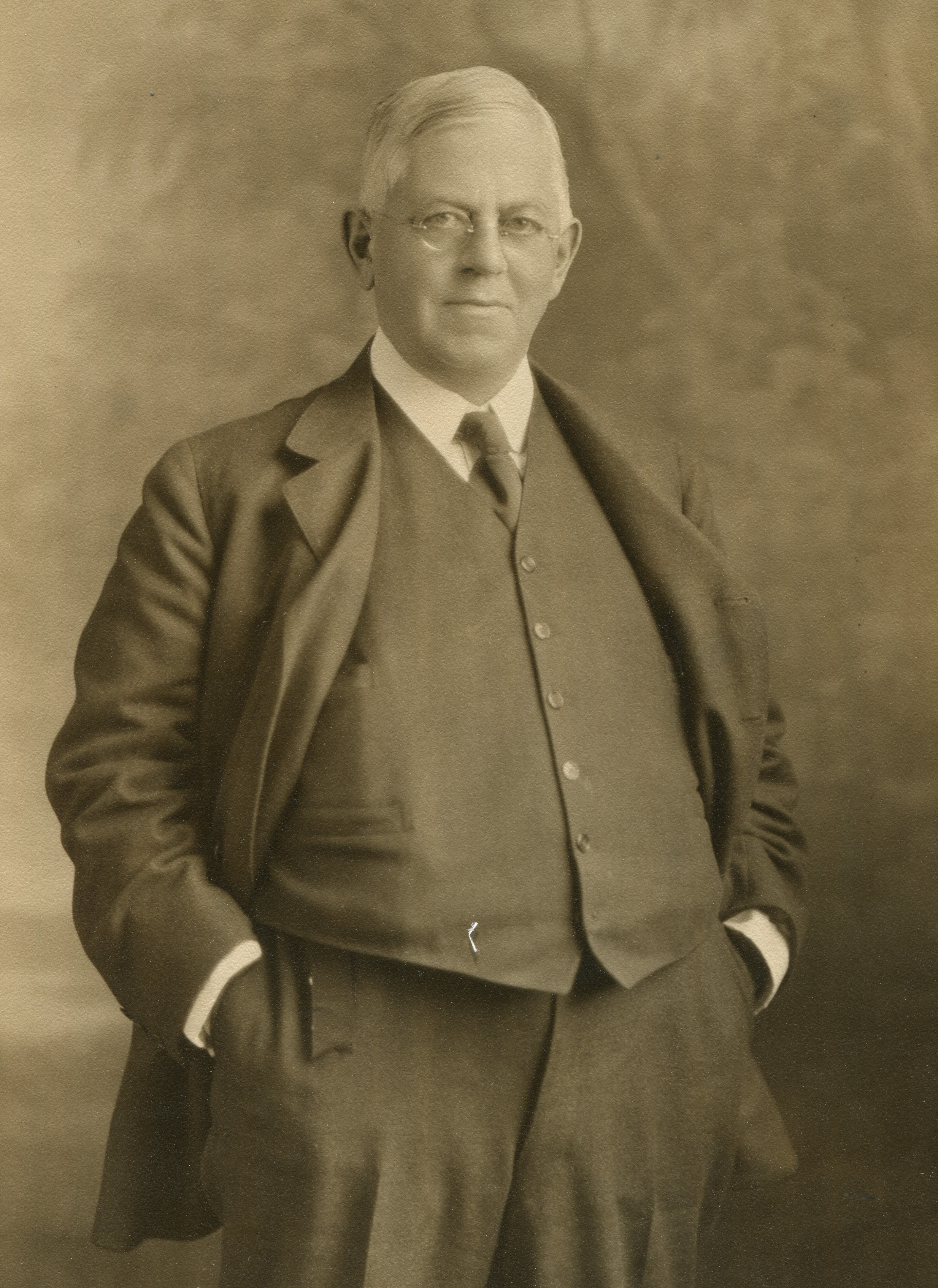 A sepia colored photo of George Henry Browne with white hair wearing a 1920s era suit.