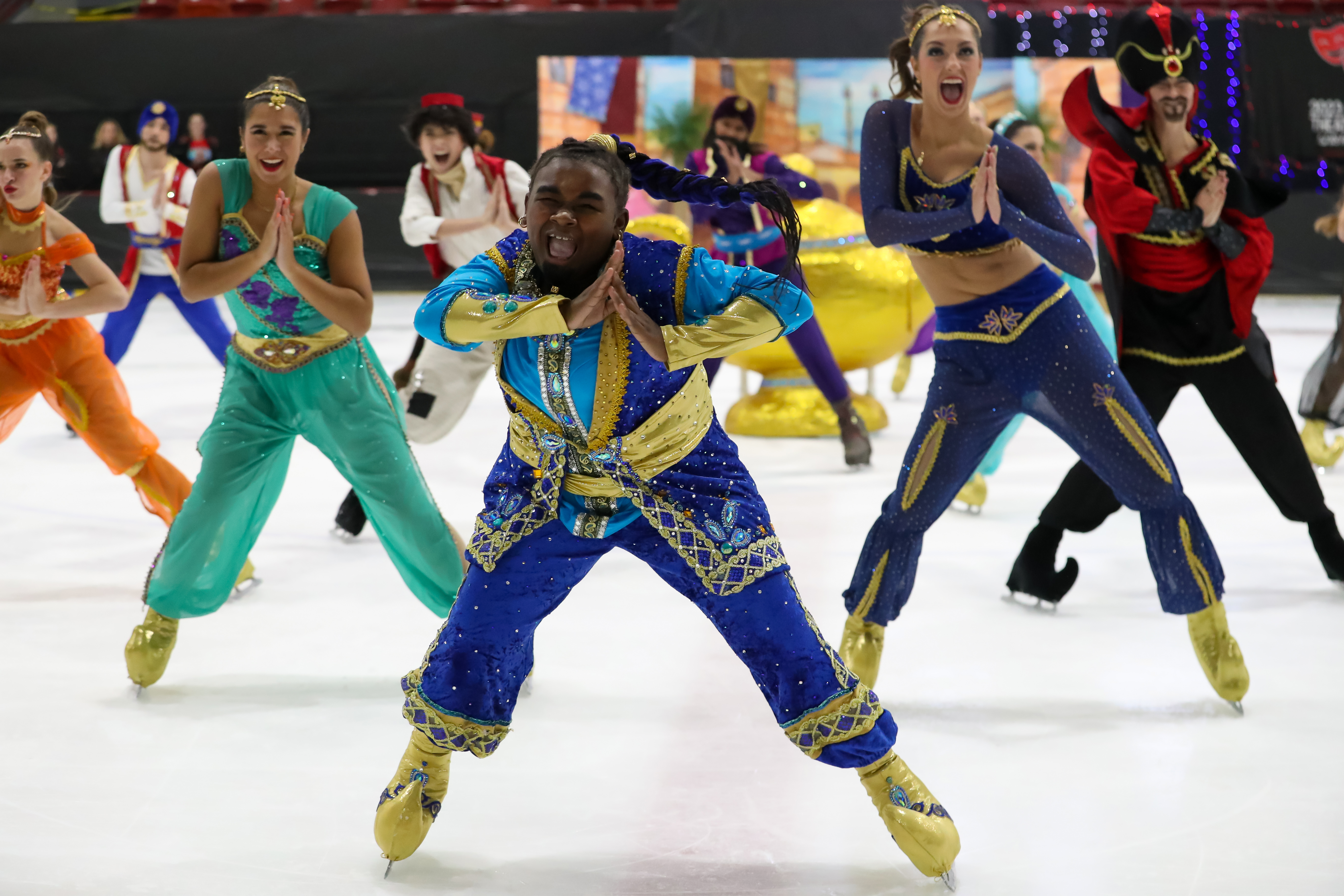 Space Coast Hurricanes Intermediate team competes in the free performance. They are all dressed in costumes inspired by the Disney movie Aladdin. A skater dressed as the genie stands in the middle 