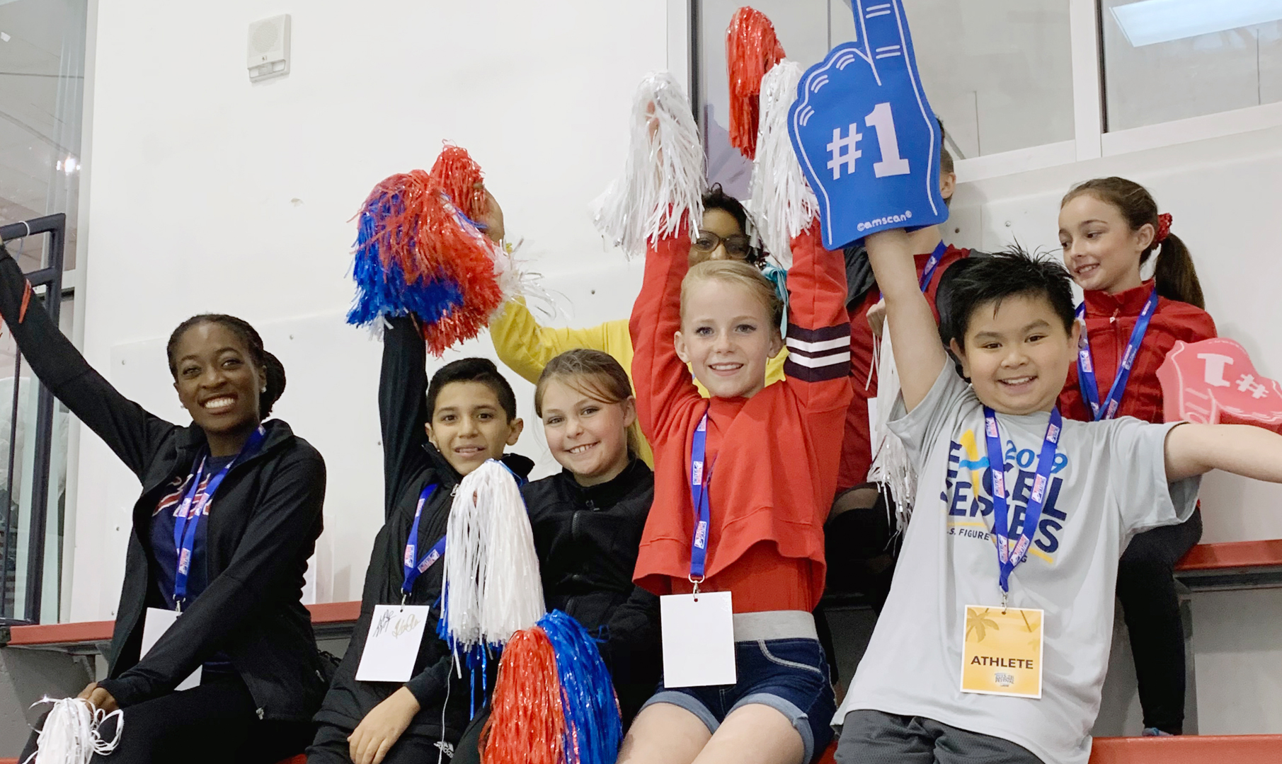Athletes cheer on skaters at a competition.