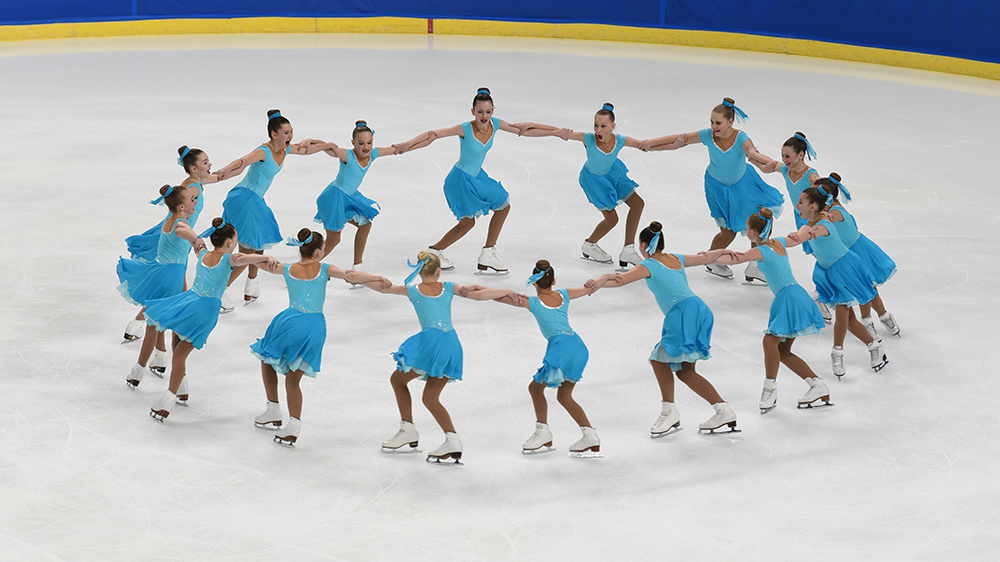 A juvenile synchro team performs a rotational element