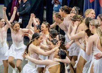 Miami University, wearing white dresses, celebrate in the kiss and cry