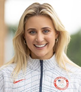 Headshot of Ashley Cain. Ashley is a young woman with shoulder length blonde hair wearing a white jacket with the Olympic emblem. 
