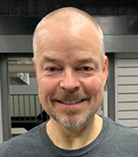 Headshot of David Santee. David is an older bald man with a grey beard wearing a grey tshirt
