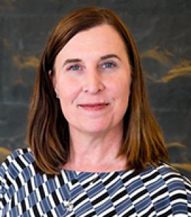 Headshot of Lisa Hernand. Lisa is an older woman with shoulder length brown hair wearing a blue, black and white shirt. 