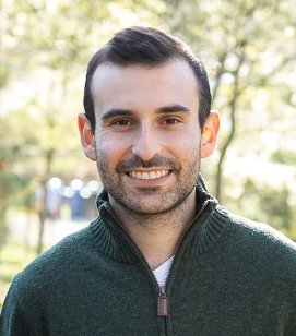 Headshot of Scott Brody. Scott is a man with short black hair and a beard. He is wearing a dark green quarterzip sweater